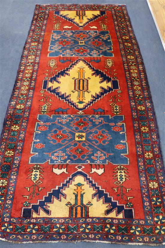 A Persian red ground rug, 10ft x 4ft 6in.